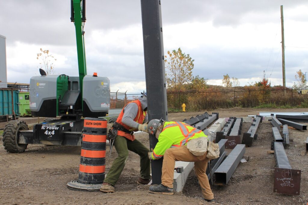 Ironworkers install the first of 228 steel structural columns in the ongoing construction of the new cutting-edge Stellantis North America Battery Technology Centre located at the Automotive Research and Development Centre (ARDC) in Windsor, Ontario.