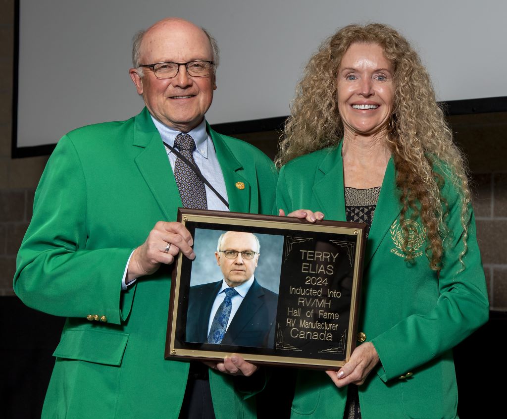 Terry Elias receives his RV/MH Hall of Fame induction plaque from Debbie Brunoforte