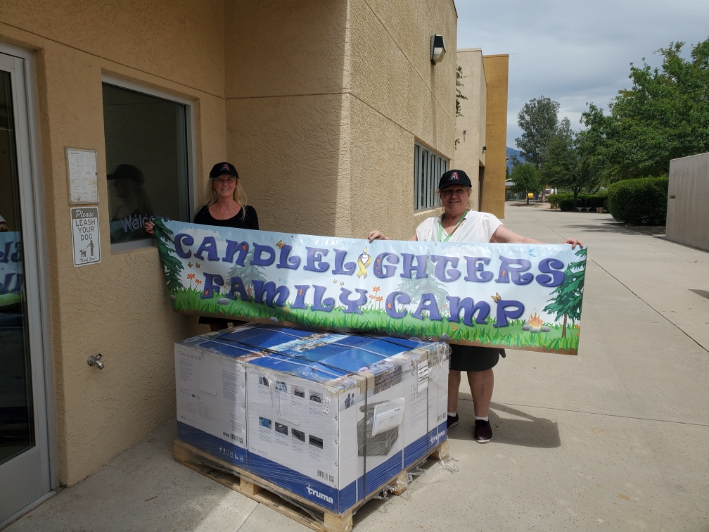 Lori Mitts and Beverly Tidwell of Candlelighters Childhood Cancer Foundation of Southern Arizona receive their C105 Truma Cooler Portable Fridge/Freezers