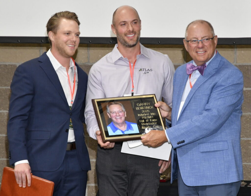 Brydon and Justin Bewernick accept their father Garry Bewernick's RV Hall of Fame Class of 2025 plaque from Gary Sieber.