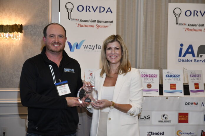 Keith Barrick, of Keith's Trailer Sales, Orton, Ontario, receives the ORVDA Dealer of the Year Award from Natalie Conway.