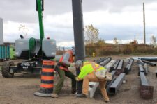 Ironworkers install the first of 228 steel structural columns in