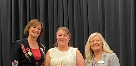 Susan Carpenter, left, and Tracy Anglemeyer, far right, present the 2025 RVWA Champion of Women Award to Brandy Droptiny, Customer Service Manager at Winnebago Towables