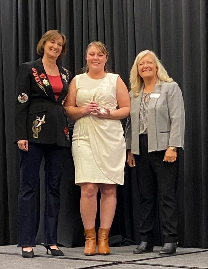 RVWA Champion of Women Award winner 2025 Brandy Droptiny, Customer Service Manager at Winnebago Towables Susan Carpenter, left, and Tracy Anglemeyer, far right, present the 2025 RVWA Champion of Women Award to Brandy Droptiny, Customer Service Manager at Winnebago Towables